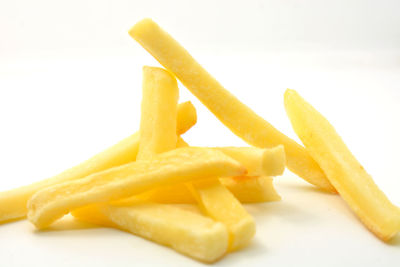 Close-up of fries on yellow plate against white background