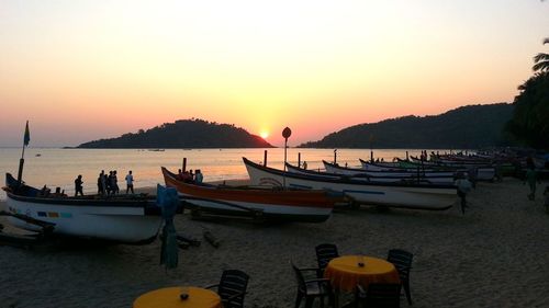 Boats in sea at sunset