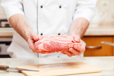 Midsection of man preparing food on cutting board