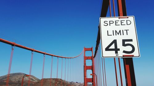 Speed limit sign on golden gate bridge against clear blue sky on sunny day