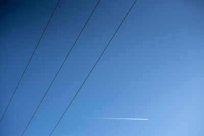 Low angle view of cables against clear blue sky