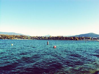 Scenic view of sea and mountains against clear sky