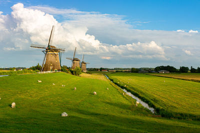 Traditional windmill on field against sky