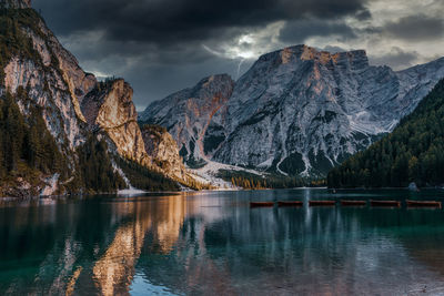 Scenic view of lake by snowcapped mountains against sky