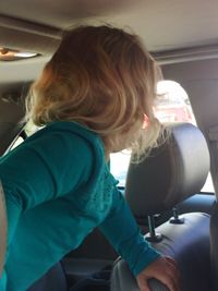 Rear view of woman sitting in car