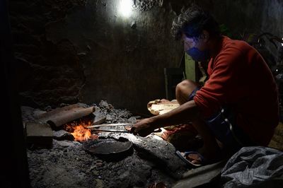 Rear view of man working on barbecue grill