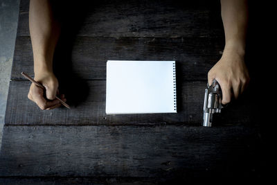 High angle view of woman reading book on table