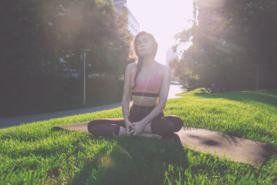 Woman sitting on grass in field