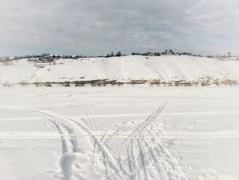 Snow covered land against sky