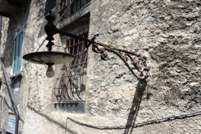 Low angle view of electric lamp hanging on wall