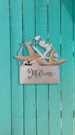 Close-up of welcome sign on wooden door