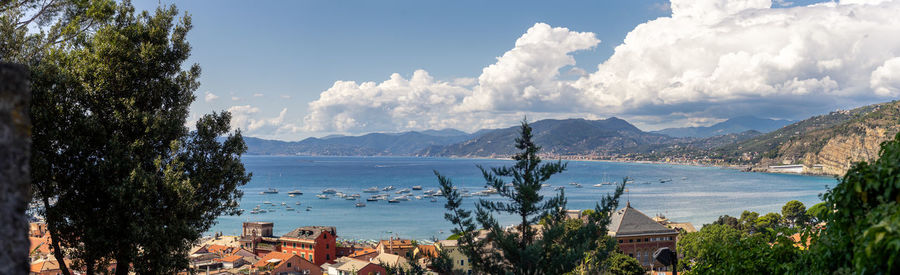 Panoramic view of city by sea against sky
