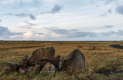 Hay bales on field against sky