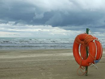 Red umbrella on beach against sky