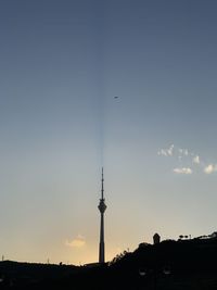 Silhouette of communications tower in city