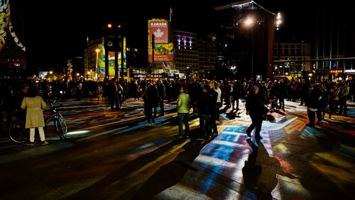 People walking on city street at night