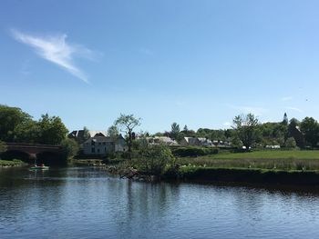 Scenic view of lake by building against blue sky