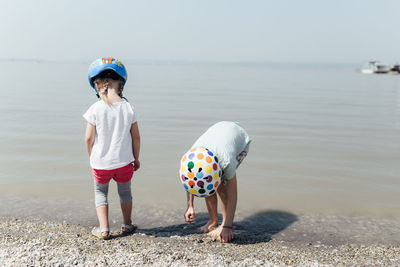 Full length of boys on beach against sky