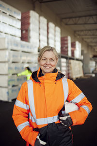 Portrait of smiling female blue-collar worker in protective workwear at factory
