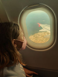 Girl looking at airplane window