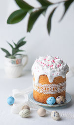 Traditional easter cake, decorated with glaze and lace ribbon with colored quail eggs. 