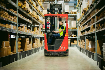 Worker driving forklift in factory