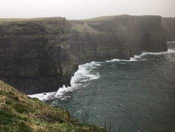 Scenic view of cliff by sea