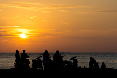 Silhouette people on beach during sunset