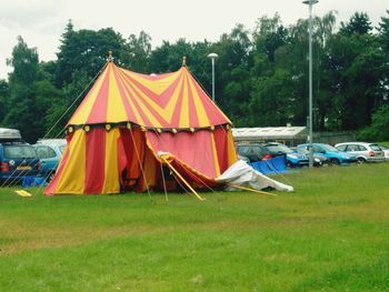 Tent on field against cloudy sky