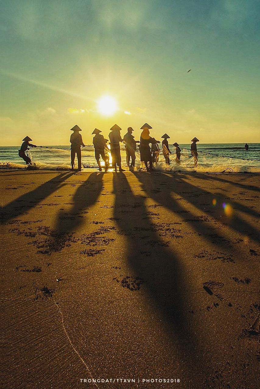 PEOPLE ON BEACH AT SUNSET