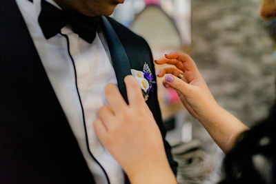 Midsection of woman adjusting groom boutonniere