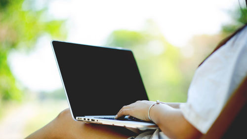 Midsection of woman using laptop