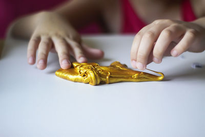 Close-up of hands holding clay on table