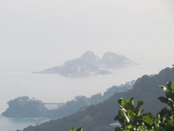 Scenic view of sea and mountains against sky