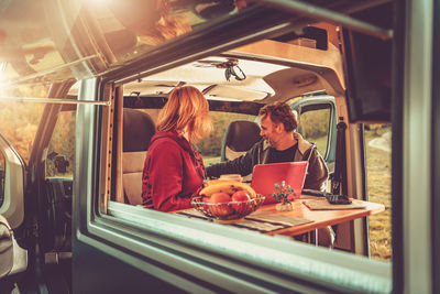 Woman with man sitting in camper van