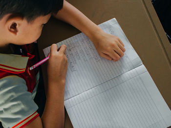 High angle view of man reading book on table