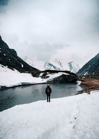 Rear view of man walking on snow covered mountain