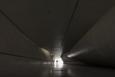 Person walking in illuminated tunnel