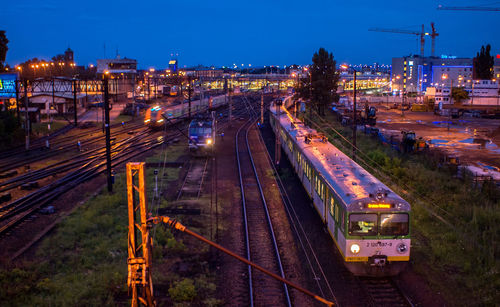 High angle view of train on illuminated railroad tracks at night