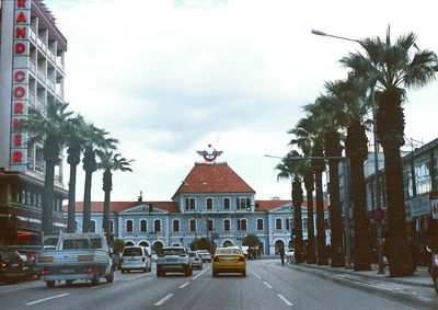 Cars on road amidst buildings in city against sky