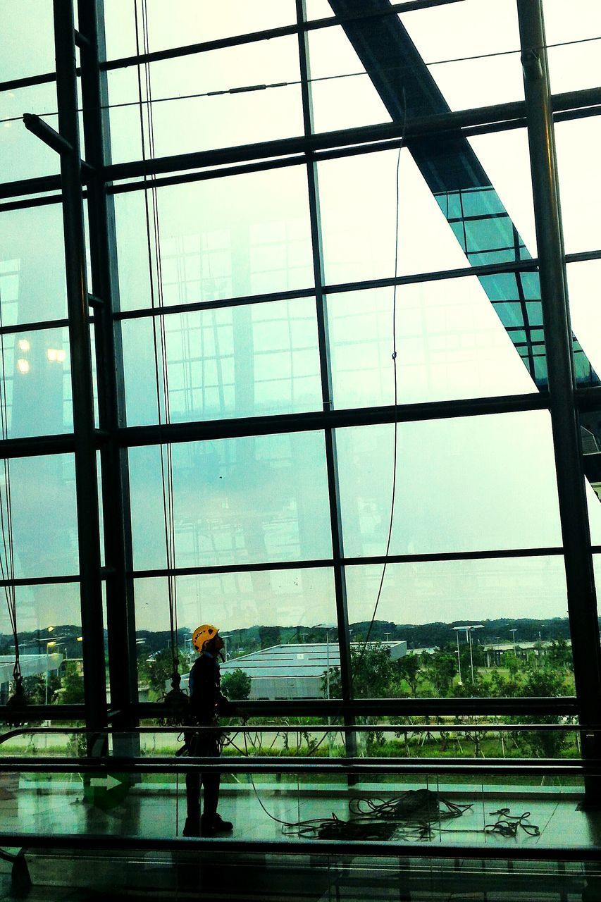 MAN STANDING IN MODERN BUILDING