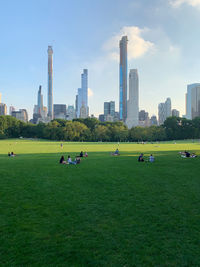 People in central park in front of new manhattan skyscrapers 