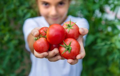 Portrait of girl holding tomatoes in hand