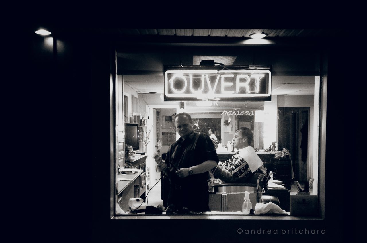 indoors, men, text, communication, lifestyles, person, western script, non-western script, leisure activity, illuminated, store, architecture, sitting, rear view, built structure, standing, information sign