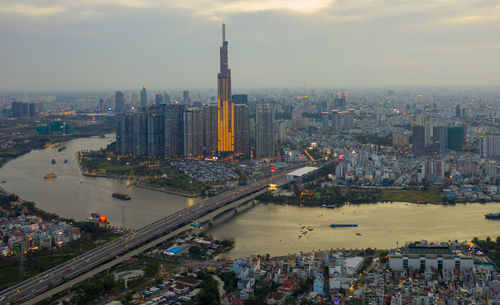 High angle view of city buildings against cloudy sky