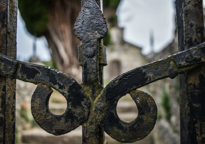 Close-up of rusty metal fence in cemetery