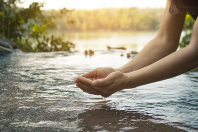 Cropped hands over river