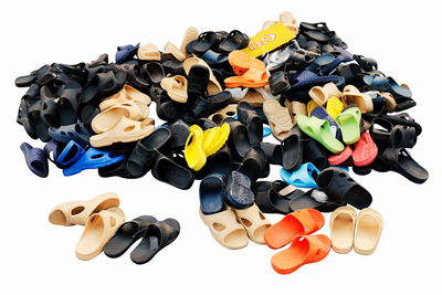 High angle view of multi colored flip flops against white background