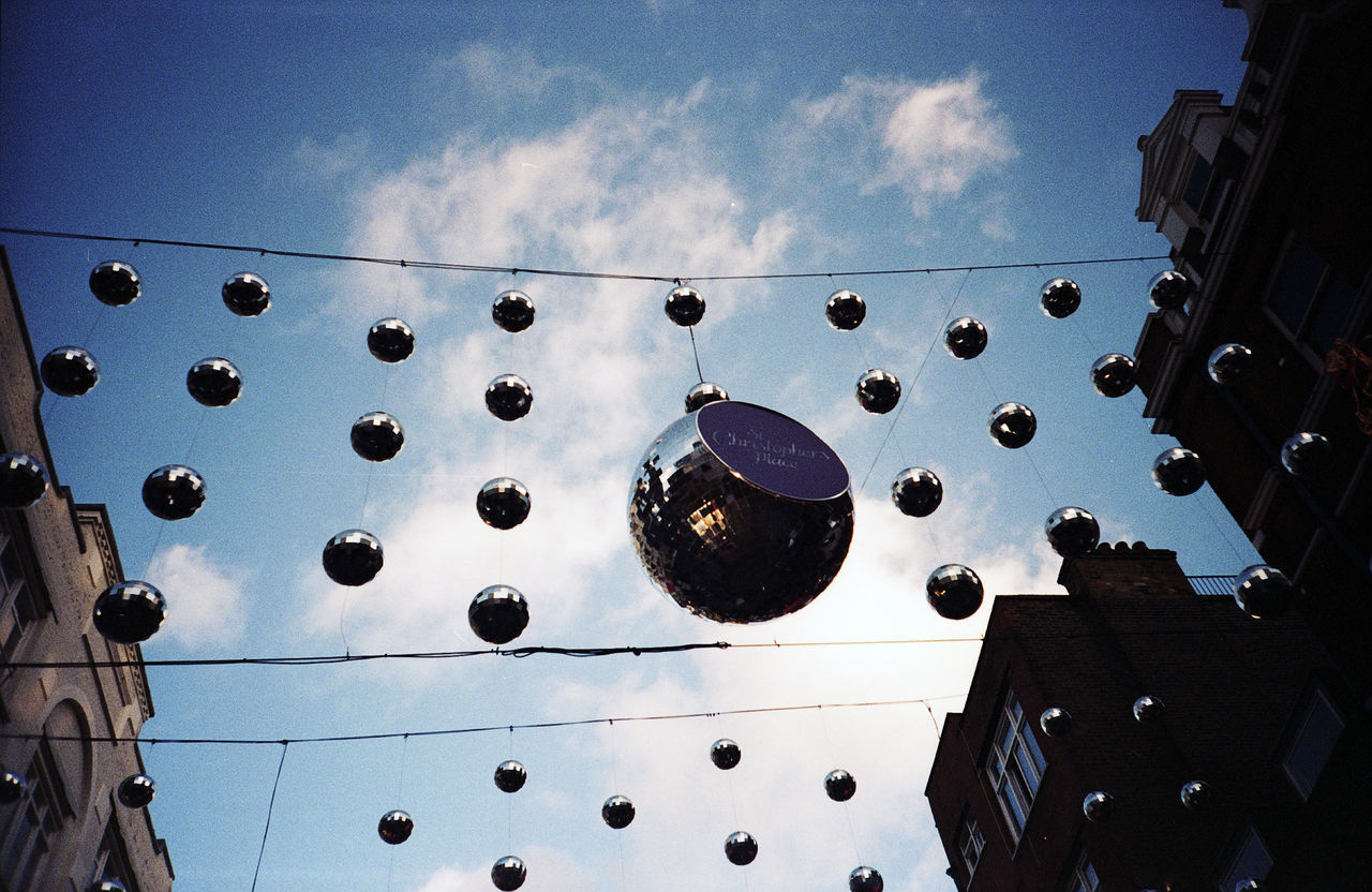 LOW ANGLE VIEW OF LIGHTING EQUIPMENT HANGING AGAINST BUILDING