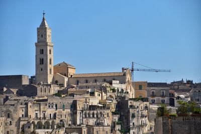 Buildings in city against clear sky